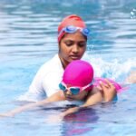 Young child learning to swim with an instructor
