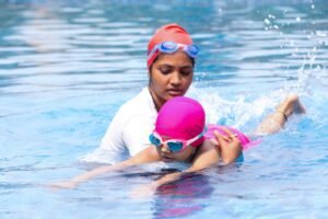 Young child learning to swim with an instructor