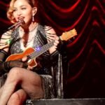 Madonna performing on stage with a ukulele