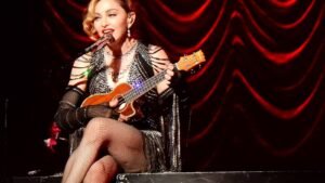 Madonna performing on stage with a ukulele