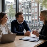 An expat couple discussing legal documents with a mediator in a bright office overlooking Amsterdam canal houses.