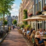 Outdoor scene of people dining at cafés along a street with traditional Amsterdam buildings and bicycles.
