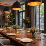 A private dining room with a long table set for a team dinner, overlooking Amsterdam canals through large windows.