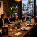 Business professionals having dinner together at a stylish restaurant with canal views in Amsterdam.