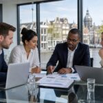 A group of professionals discussing financial documents around a table with a view of Amsterdam canals and buildings through large windows.