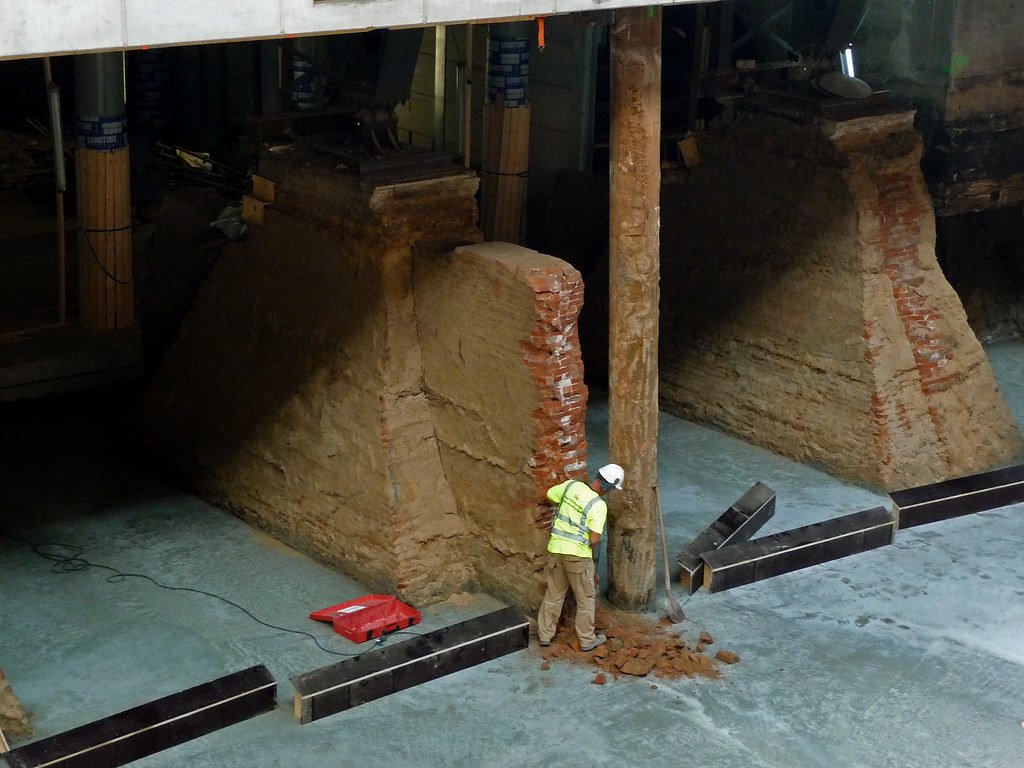 A construction worker in a high-visibility vest working on building foundations in Amsterdam