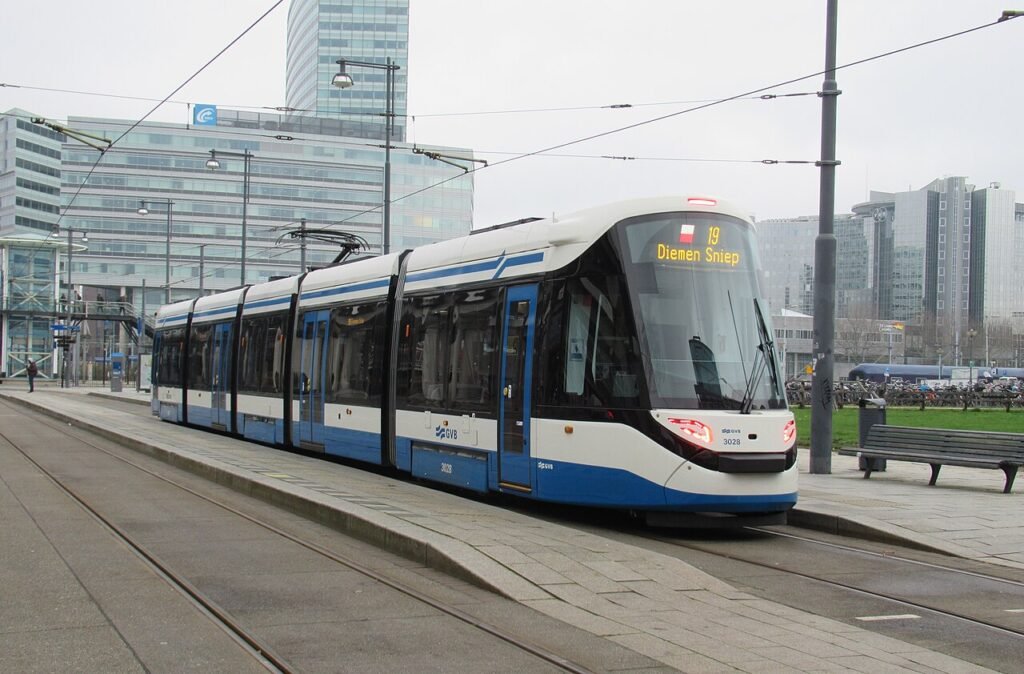 A blue and white GVB tram on an Amsterdam street