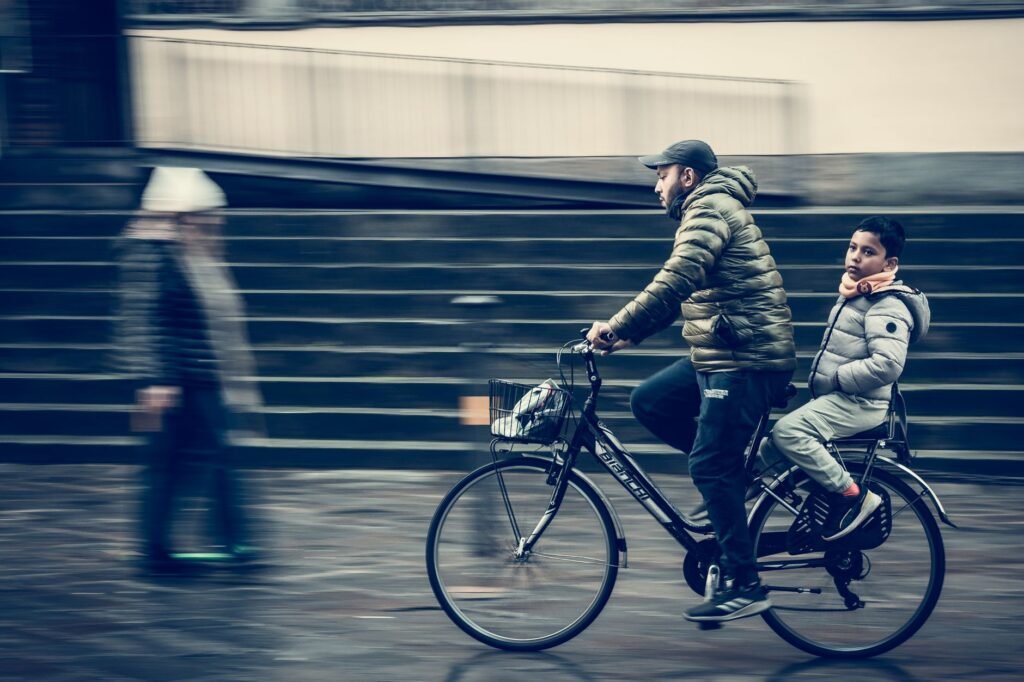 A parent cycling alongside a child on a city street