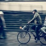 A parent cycling alongside a child on a city street