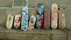 Hand-painted skateboard decks lined up against a wall