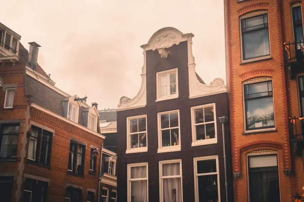 Amsterdam canal house with a neck gable, dormer windows on the roof next door