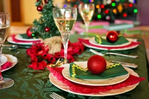 A Christmas dinner table set with glasses and decorations