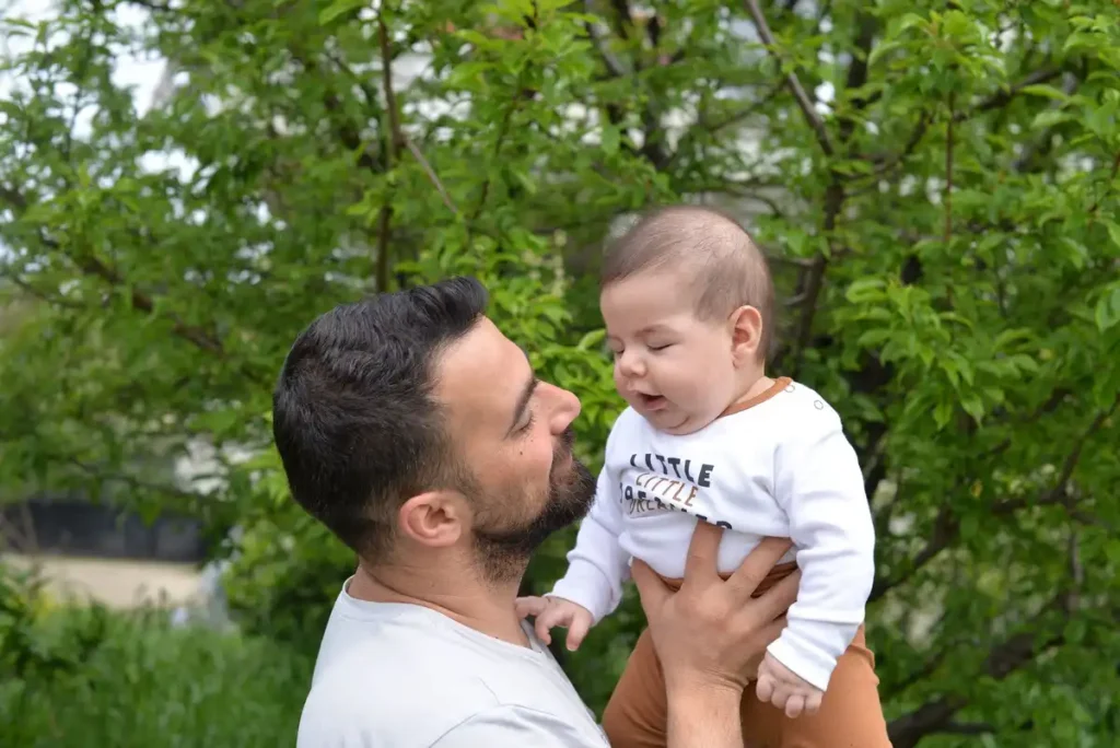A father lifting his baby outdoors