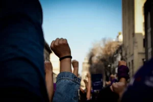 Women marching with purple scarves on International Women's Day