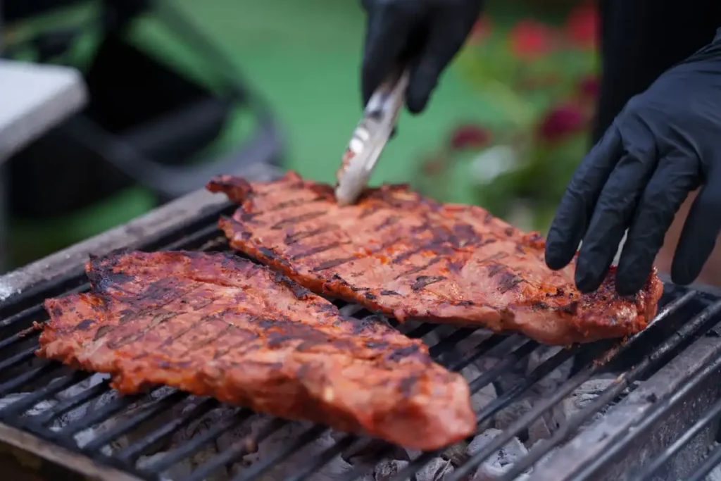 Steaks grilling over charcoal