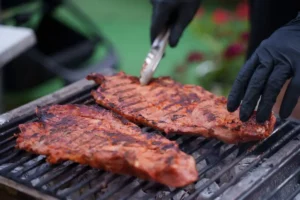 Steaks grilling over charcoal